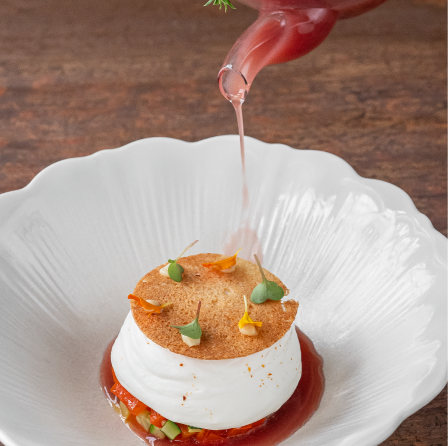 Dessert délicat avec une touche de sirop versé dans une assiette blanche élégante.
