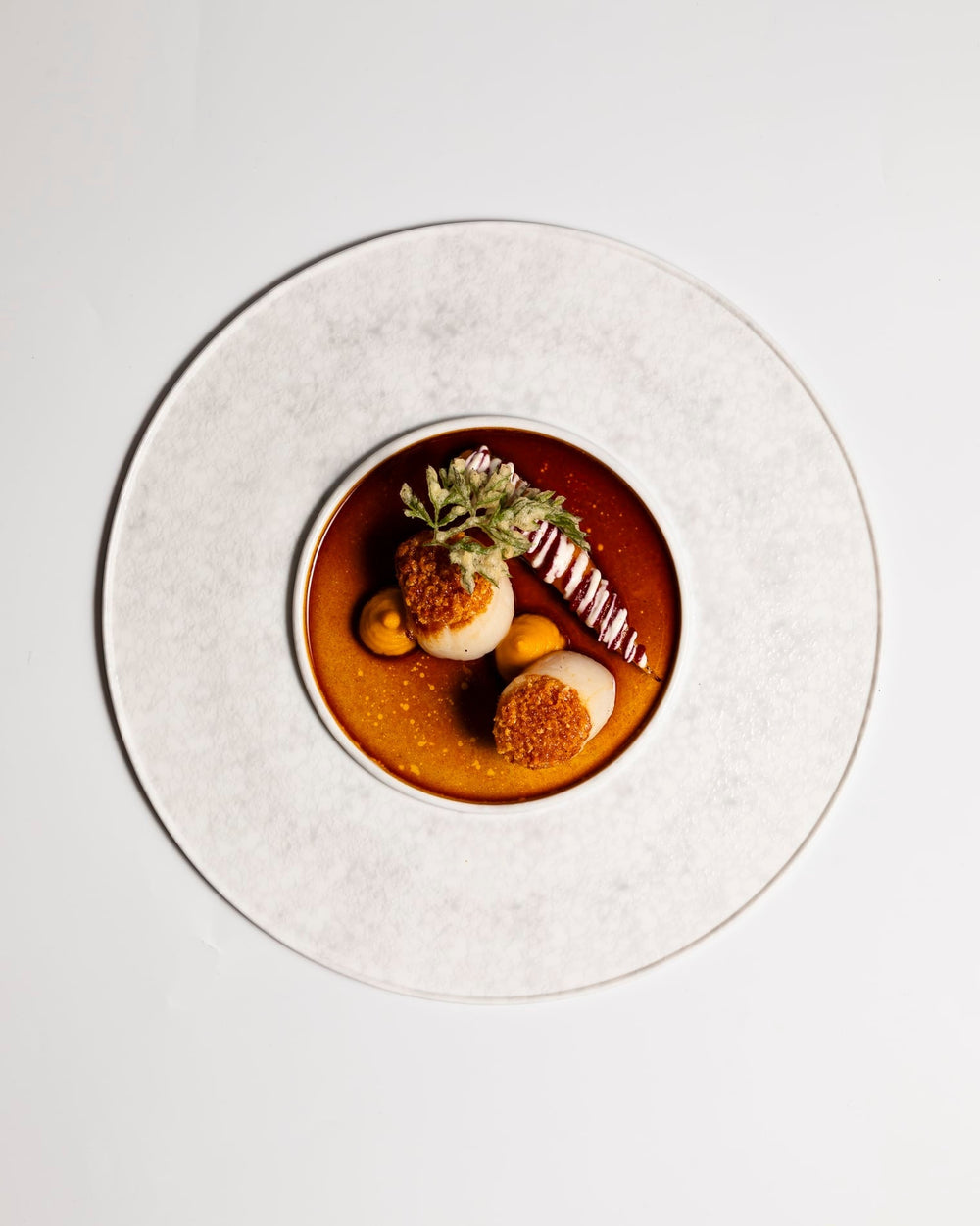 Plat gastronomique avec sauce brune et garnitures.