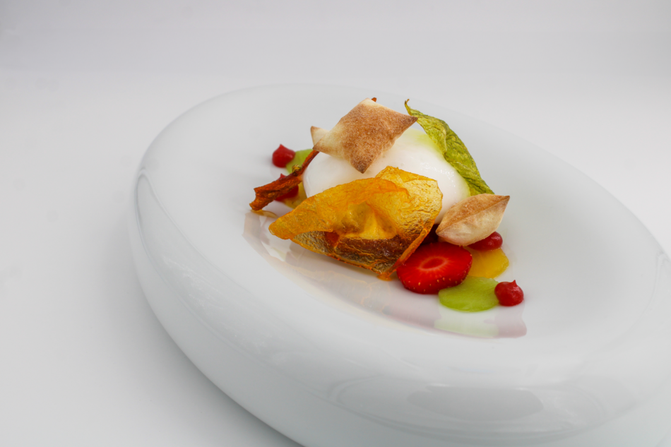 Plat gastronomique avec une présentation artistique de fruits et légumes sur une assiette blanche.